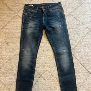 Mörkblå jeans från Jack & Jones - Snygga mörkblå skinny jeans från Jack & Jones med slitna detaljer och lätt tvättade partier | Storlek 31/32 | skick 9/10 | modell: Skinny Liam! Kontakta vid frågor och funderingar!
