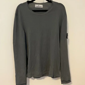 Stone Island tröja - Snygg grå långärmad tröja från Stone Island.  Tröjan är tillverkad i mjuk bomull och har en clean och stilren look. Den är L men passar även M. Hör av er vid funderingar. 
