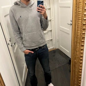 Grå hoodie från Polo Ralph Lauren XL - Säljer en klassisk grå hoodie från Polo Ralph Lauren i storlek XL barn dvs S, modellen är 180. Tröjan har huva, magficka och den ikoniska lilla broderade loggan på bröstet. Tillverkad i mjuk bomullsmix, perfekt för chill dagar eller när du vill ha en clean och enkel stil.