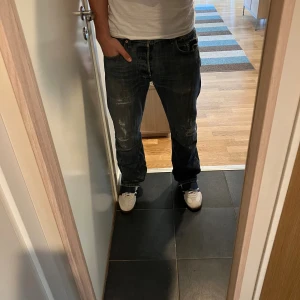 Levis 501 - Riktigt feta levis 501 jeans me sjuka slitningar. Storlek 33 i midjan och 34 längd. Sitter riktigt nice som ni kan se på bilderna. För referens är jag 185 och väger 78, kom privat vid fler frågor!