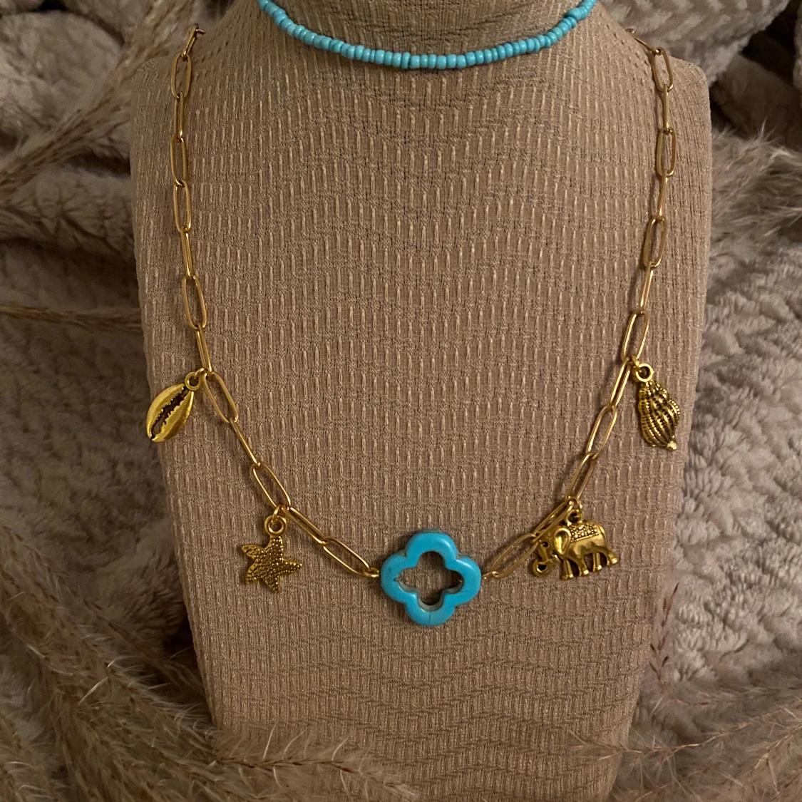 Två halsband med turkosa och guldiga detaljer