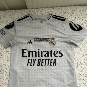 Real Madrid Mbappé Supercup tröja - Säljer en officiell Real Madrid UEFA Supercup fotbollströja med Mbappé och nummer 9 på ryggen. 