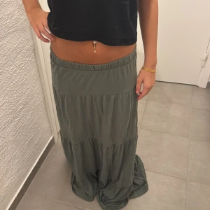 Grön långkjol från Vero Moda XS - Superskön långkjol från Vero Moda i en dämpad grön färg. Kjolen har resår i midjan och flera volanger som ger en avslappnad och flowy känsla. Den är för lång för mig som har korta ben och är 155.