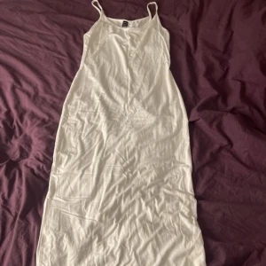 Vit långklänning från SHEIN - Enkel och stilren vit långklänning från SHEIN med tunna axelband. Klänningen har rak passform och är tillverkad i ett mjukt material som känns skönt mot huden. Perfekt för varma dagar eller när du vill ha en clean look.