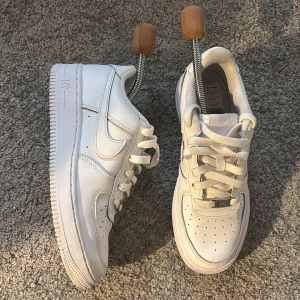 Nike Air Force 1 vita sneakers - Fräscha Nike Air Force 1 sneakers i helvitt skinn med klassisk låg siluett. De kommer från Nikes hemsida, kvalitet: 8,8/10 använd fåtal gånger. Nypris: 1095kr.