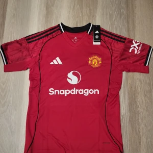 Manchester United röd matchtröja 2025/26 - Säljer en officiell Manchester United fotbollströja från 2025/26.Materialet är lätt och ventilerande polyester. Priset kan diskuteras vid snabb köp. Kan skickas direkt 