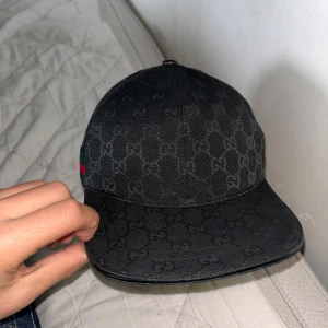 Svart Gucci keps - Säljer en svart gucci keps som använts bara denna sommar, har tröttnar och vill ändra stil. Inga detaljer eller defekter. Vid fler bilder o funderingar de är ba o kontakta. Inga tecken på användning