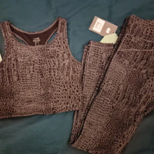Grå croco träningsset från Casall - Snyggt grått set från Casall med croco-mönster och racerback bh. Perfekt för träning, med en tight passform och tillverkad i mjukt syntetmaterial som andas. Coolt tryck och stilren design som ger extra edge till din träningsoutfit. Nypris ca 1100 kr för båda. 