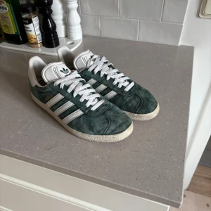 Adidas gazelle skor  - Adidas gazelle skor i storlek 44. Färgen än mörkgrön och skorna är perfekta inför vintern!