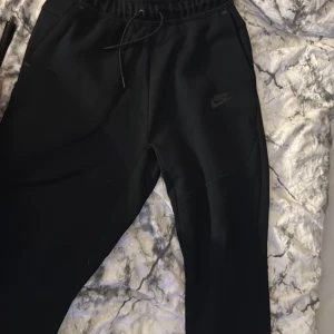 Svarta nike tech storlek 158 - 170 cm - Svarta mjukisbyxor från Nike i storlek 158 - 170 cm. Använda 1 / 2 gånger 