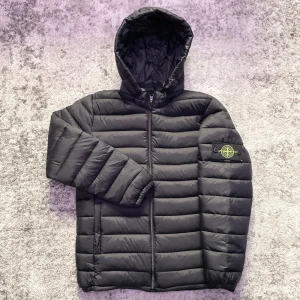 Svart Stone Island jacka - Riktigt fin dunjacka med borttagbar luva, nytt skick i storlek M. Perfekt för en stilren look med eller utan luva och värmer samtidigt bra för kyligare dagar❄️. Hör gärna av dig vid minsta fundering om t.ex mått, fler bilder eller pris!