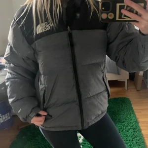 Grå och svart pufferjacka The North Face - Säljer en grå och svart pufferjacka från The North Face, inga defekter pga att den nästan aldrig kommit till användning 