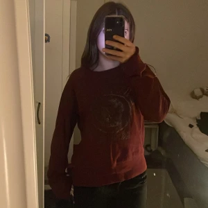 Mörkröd sweatshirt  - Säljer en mörkröd sweatshirt med ett coolt tryck på framsidan från DIVIDED, de är storlek L men skulle säga att den är som xs! 💗 