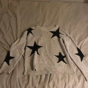 Grå stickad tröja med svarta stjärnor - Grå stickad tröja med svarta stjärnor från shein, storleken står inte men passar mig bra jag har i vanliga fall S, 30kr 