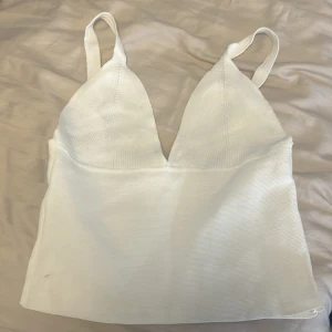 Vit ribbad topp - Söt topp som är croppad och har en stilren, enkel design som passar till mycket. Materialet är mjukt och stretchigt