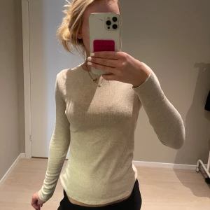 Beige ribbad långärmad tröja MNG - Superskön beige långärmad tröja från MNG i ribbat material. Sitter tajt och har en klassisk rund halsringning. Perfekt att styla med jeans eller kjol för en clean och enkel look.