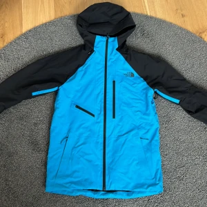 The North Face skidjacka - En blå svart skidjacka i Gore-tex i väldigt bra skick, inte  mycket använd. Bra fickor med fungerande dragkedjor. Hämtas helst i Järfälla i Stockholm, går att skicka också på posten om det behövs.