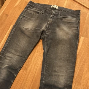 Grå jeans från Acne Studios - grå jeans från Acne Studios med slitningar med en riktigt snygg tvätt. Klassisk femficksmodell med skinny passform. Riktigt bra skick och köpta i stockholm för ett par år sedan. Tajta runt benen