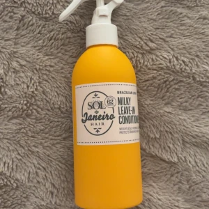 Sol de Janeiro Milky Leave-In Conditioner - Sol de Janeiro Milky Leave-In Conditioner i en snygg gul plastflaska med vit spraypump. Produkten är framtagen för att återfukta och skydda håret mot värme. Doftar ikoniskt och är lätt i konsistensen. Perfekt för dig som vill ha mjukt och glansigt hår. 