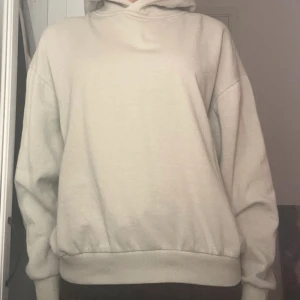 Grön hoodie med huva - Enkel och stilren grön hoodie med huva och långa ärmar. Tröjan har ribbade muddar vid ärmslut och nederkant, samt en avslappnad passform. Perfekt för chill dagar eller när du vill ha en clean look.