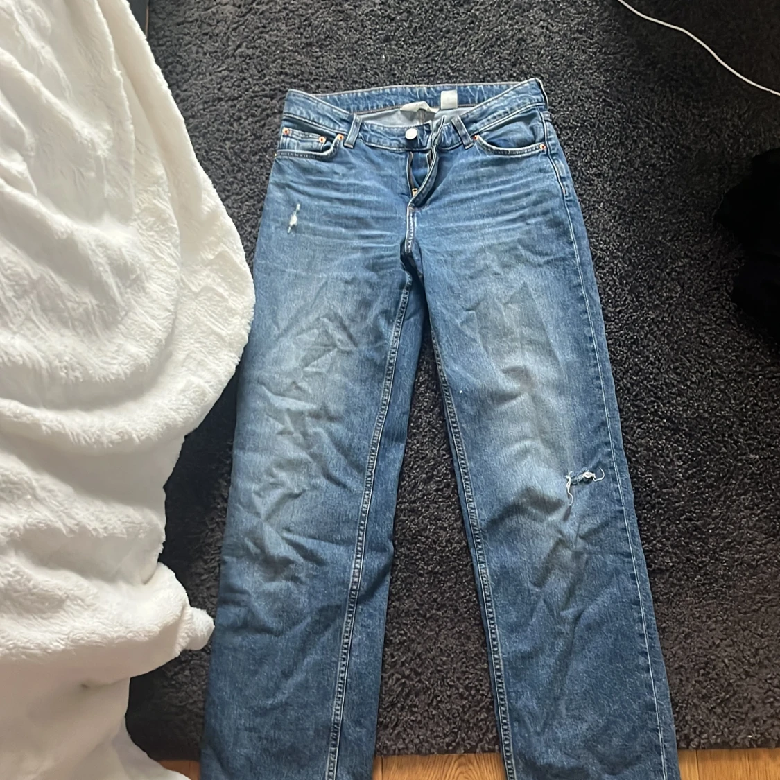 Blå raka jeans med slitningar