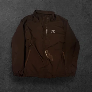 Svart vattentät jacka från Arc'teryx S - Svart svart jacka från Arc'teryx med sportig look, meshfoder och hög krage. Jackan har dragkedjor på fickorna och diskreta ventilationshål vid halsen. Perfekt för dig som gillar stilren och funktionell design. Gore tex