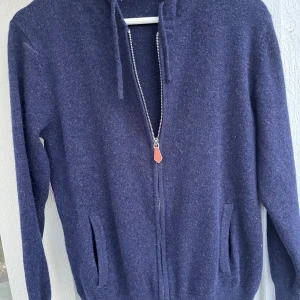 Marinblå hoodie i Kashmir  med dragkedja - Kashmir Hoodie, Marinblå, Strl. XS Säljer en lyxig och supermjuk luvtröja i 100% Kashmir. Perfekt basplagg. • Färg: Marinblå • Storlek: XS • Detaljer: Dragkedja med snygg läderdetalj, luva, fickor. • Skick: Mycket fint. 