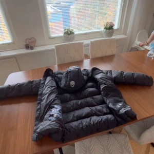 Svart vinterjacka från sailracing - Säljer en svart dunjacka från sailracing med huva och dragkedja framtill. Jackan är perfekt för vintern och är riktigt varm. Jackan har bra kvalité. Storlek 176