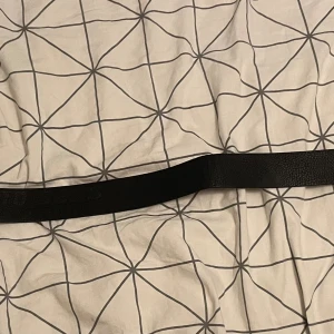 Svart skärp från Hugo Boss i skinn - Snyggt svart bälte från Hugo Boss med präglad logga längs remmen och en stilren metallspänne där BOSS är ingraverat. Bältet är gjort i äkta skinn med lätt texturerad yta och klassisk form. Perfekt för att lyfta din outfit med en exklusiv touch. Den är lite skrynklig men går att använda, skulle inte säga den är helt fräsch. PRIS KAN ABSOLUT DIAKUTERAS!!