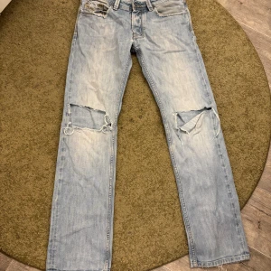 Ljusblå straight jeans från Diesel - Säljer ett par ljusblå jeans från Diesel med raka ben och slitna detaljer vid knäna. Klassisk femficksmodell med snygga sömmar och patch bak i midjan. Perfekt för dig som gillar en avslappnad och cool stil. ( tvättas innan postning) 