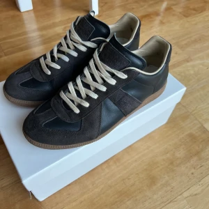 Maison Margiela Gats - Maison Margiela Gats, kommer med originalbox och skopåsar. Säljer pga att jag får skoskav av dem, vilket har gjort att det blivit ett litet märke i hälen på ena skon (syns på sista bilden).