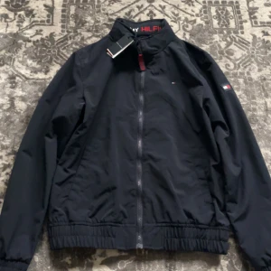 Tommy hilfiger  - Säljer denna vindjackan för den är bara hängt i garderoben och aldrig använt. Storleken är 164
