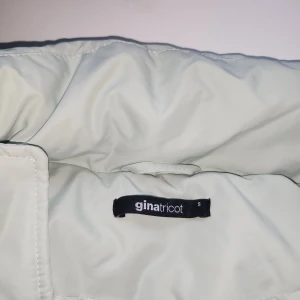 Ljusgrön pufferjacka från Gina Tricot - Säljer en ljusgrön pufferjacka från Gina Tricot i storlek S. Jackan har dragkedja framtill, två fickor med dragkedja och justerbar dragsko nertill. Perfekt för kyliga dagar och ger en cool, avslappnad vibe.