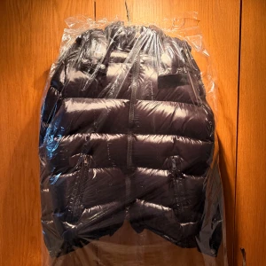 Svart Moncler pufferjacka - Säljer min svarta Moncler-jacka i modellen Maya i storlek M. Den är köpt här på Plick förra året och köpte den i nyskick. Den har vissa defekter som syns på bilderna, ingenting som märks av. Jackan har precis kommit ut från kemtvätt och är som ny. Jag har tyvärr inget kvitto men hör gärna av dig om du vill ha fler bilder eller om du har några frågor 🥰
