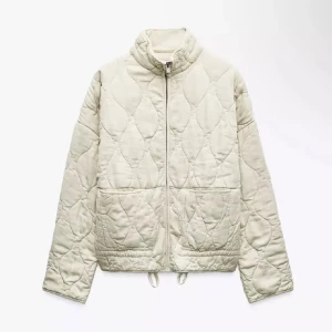 Quiltad vit jacka från Zara - Quiltad jacka från Zara i ljusvit färg med snyggt mönster och dragkedja framtill. Jackan har två stora fickor, hög krage och snörning nedtill. Har två fläckar !! En på baksida och en fram ficka, därav priset !! Skriv vid frågor och fler bilder 🩷säljs inte längre på hemsidan och nypris är 800kr