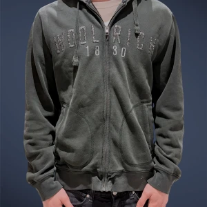 Mörkgrön hoodie från Woolrich - Asfet kofta från Woolrich i stl L/M. Den har en fodrad luva med lammull vilket gör den varm och tjock. Lägg ett prisförslag så kommer vi överens om nåt.🤩Modellen är 184 cm , väger 73 ish kg