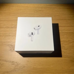 AirPods Pro 2 i nytt skick - Hej! Säljer mina AirPods Pro 2 då jag har tänkt uppgradera till AirPods Pro 3. Hörlurarna är i toppskick och har alltid hanterats med stor försiktighet. Fodralet har haft skydd sedan första dagen, så både hörlurarna och fodralet ser nästan nya ut. Allt som följer med vid nyköp ingår: laddningskabel, öronproppar i flera storlekar samt instruktioner. Dessutom får du två extra fodral – ett genomskinligt hårt och ett vitt i silikon. Köparen står för frakten och betalning sker via Swish! Ha det bra!😇