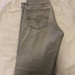 Grå Levi's 511 jeans med slitning - Snygga grå Levi's 511 jeans, defekterna dom har är att dom är smutsiga på högerbakficka och på vänster låret, annars är det inga problem med jeans 