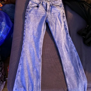 Blå bootcut jeans från Perfect Jeans - Snygga ljusblå bootcut jeans från Perfect Jeans i storlek 34. Klassisk femficksmodell med dragkedja och knapp framtill. Jeansen har raka ben med lätt utsvängd bootcut.jeansen har vart använda 1 gång.