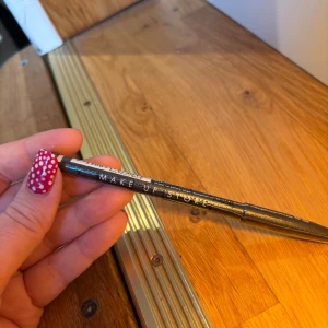 Svart ögonpenna från Make Up Store - Klassisk svart ögonpenna från Make Up Store i färgen Black. Perfekt för att skapa skarpa linjer eller suddiga looks. Pennan har en smidig form och är lätt att använda för både eyeliner och vattenlinje. Nypris 135kr