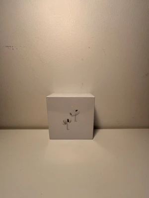 Apple AirPods 2 Pro trådlösa hörlurar - Säljer ett par vita Apple AirPods 2 Pro i originalförpackning. De är trådlösa in-ear hörlurar med aktiv brusreducering,stilren design och laddningsetui. Perfekta för musik, samtal och träning. Kompatibla med iPhone och andra Apple-enheter.