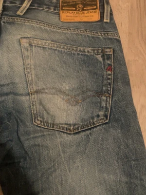 Replay Blue Jeans i ljusblå denim - Snygga Replay Blue Jeans i ljusblå tvätt med klassiska bakfickor och läderpatch i midjan. Jeansen har raka ben och normal passform, perfekta för en avslappnad stil. Hål som går att laga. Kom privat för fler bilder eller frågor.mvh