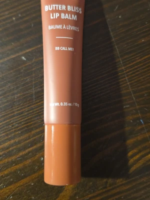 Butter Bliss Lip Balm BB Call Me! - Läppbalsam i tub från Butter Bliss i färgen BB Call Me! Tuben är brunrosa med vit text och har ett genomskinligt applikatorhuvud i plast. Innehåller 10g (0.35 oz) och är perfekt för att återfukta läpparna. Enkel att ta med i väskan.