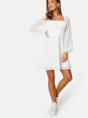 Vit studentklänning  - Superfin vit kort klänning med puffiga långärmar och fyrkantig ringning. Perfekt för studenten eller skolavslutning! Klänningen är köpt från Bubbleroom och är i nyskick med prislapp kvar.