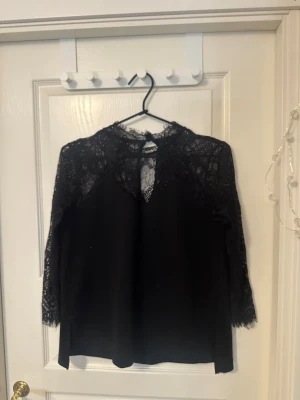 Spetsblus  - Snygg och elegant svart blus med transparent spets upptill och på ärmarna i mycket bra skick!