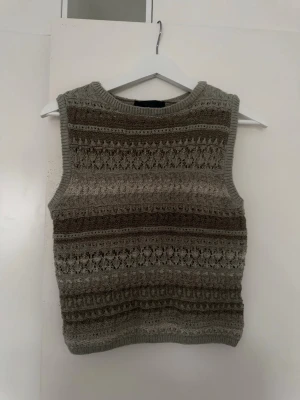Stickad ärmlös tröja från Zara – mönstrad, storlek M - Säljer en stickad ärmlös tröja (vest) från Zara i storlek M. Tröjan har ett vackert mönstrat stickat material i naturliga toner som ger en trendig och lite vintage-inspirerad look. Perfekt att bära som den är eller att styla över en skjorta eller t-shirt för en lager-på-lager outfit.  Ett snyggt och mångsidigt plagg som funkar lika bra till vardag som till mer uppklädda tillfällen.
