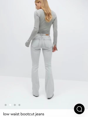 Ljusgrå bootcut med låg midja - Säljer dessa jättesnygga låg midjade jeans från gina! Jeansen har en klassisk femfickig desgin och gula stitches. Perfekt för dig som gillar en lowwasit clean look på jeans! Använda endast ett fåtal gånger och är nästan helt nya. Helt slutsålda på nätet. Skriv för fler bilder💕💕