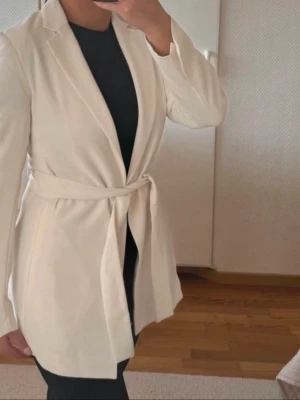 Vit kavaj med bälte - Oanvänd kavaj. Storlek 36. Köpt i H&M för 399kr.