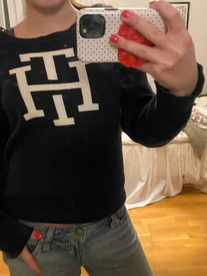 Marinblå stickad tröja Tommy Hilfiger - Säljer en marinblå stickad tröja från Tommy Hilfiger med stort vitt TH-tryck på framsidan 😍