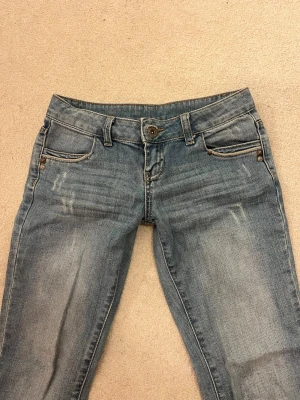 Ljusblåa jeans  - Säljer dessa ljusblåa lågmidjade bootcut jeans. De har design på bakfickorna och är i bra skick. De två sista bilderna e från tjejen jag köpte de. Skriv om ni har frågor och pris kan diskuteras!💕innerbenslängd:81cm                                                      Midjemått:38cm      